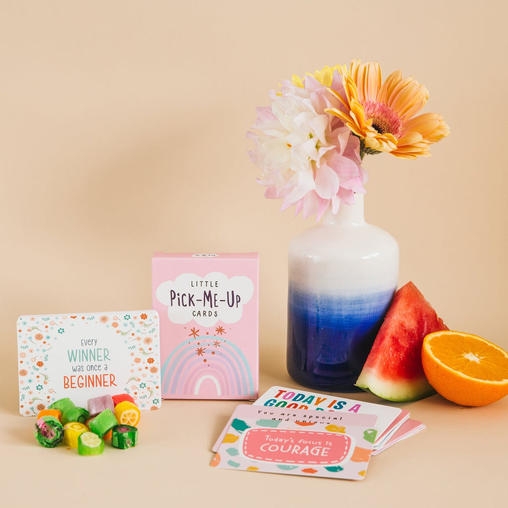 Girls Thriving little pick me up cards styled with fruit, colourful lollies and flowers in a blue ceramic vase