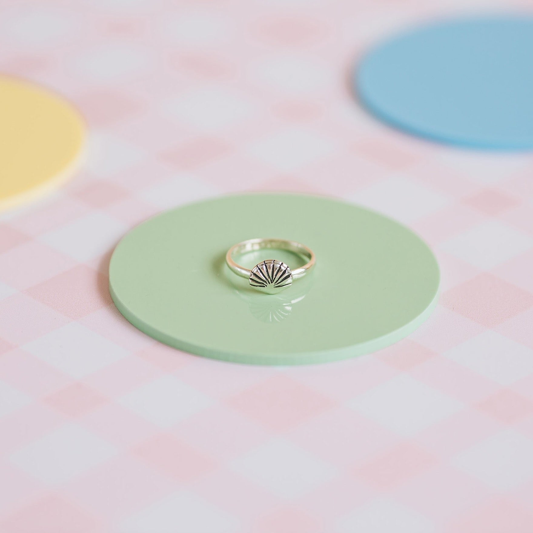 Pippin Girl Treasure Ring styled on green disc and pink check background