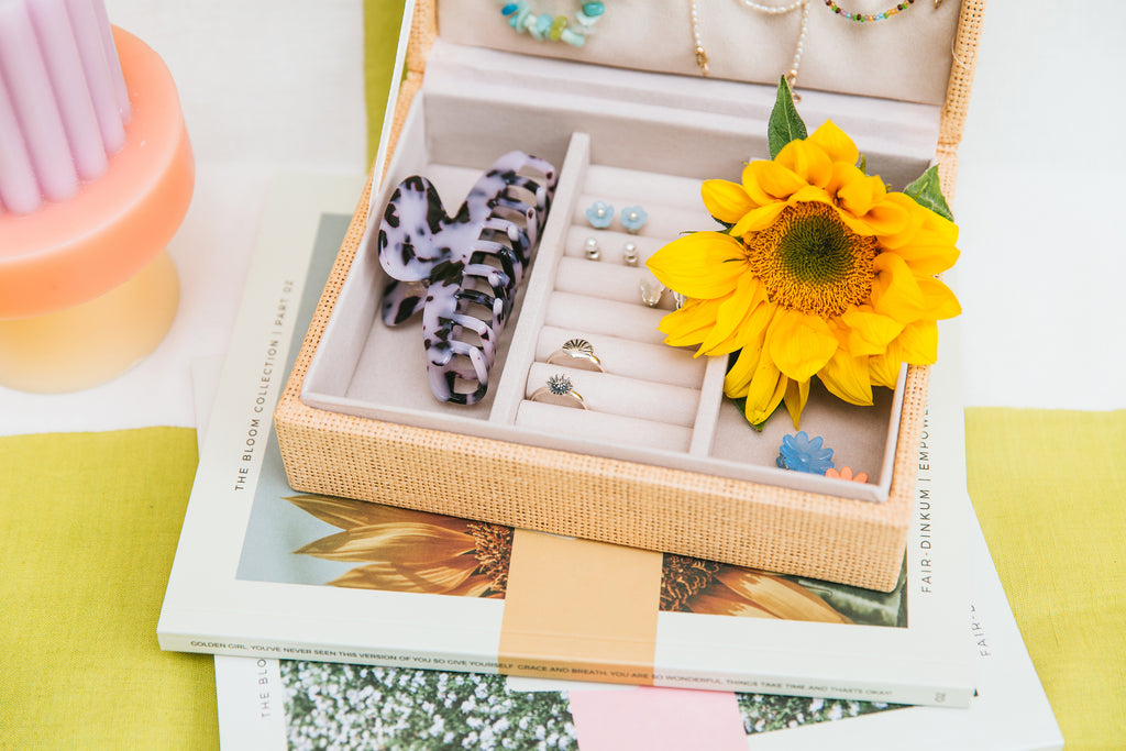The Treasure and Bloom rings inside a jewellery box. The box sits on top of two Bloom Collection books.